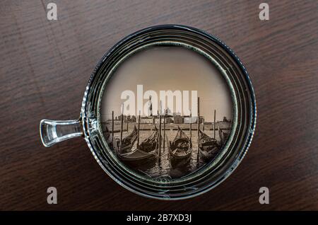 Blick auf die Tasse Kaffee auf dem Tisch mit Gondeln in Venedig, Italien Stockfoto
