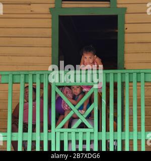 Mutter und Kinder auf einem Balkon, Coxen Hole, Roatan, Honduras Stockfoto