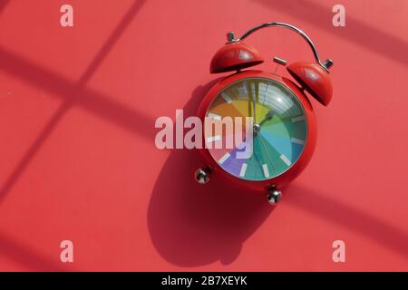 Roter Farb-Wecker auf rotem Hintergrund, Draufsicht. Stockfoto