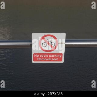 Schild "kein Fahrradparken, Entzugsgebühr", das an einem Metallgeländer mit Blick auf das Meer im Hafen von Padstow, Cornwall, England, Großbritannien angebracht ist Stockfoto