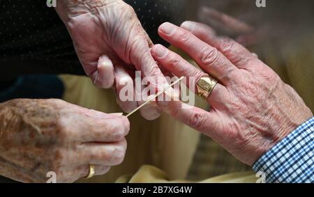 Ältere Paare in ihren Achtzigern schneiden sich zu Hause Fingernägel Stockfoto