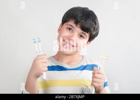 Lächelndes Kind mit Zahnbürste im weißen Hintergrund Stockfoto