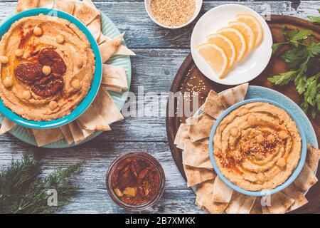 Traditioneller Hummus mit Sesamsamen und Paprika und Hummus mit sonnengetrockneten Tomaten. Traditionelle vegane gesunde Mahlzeit. Stockfoto