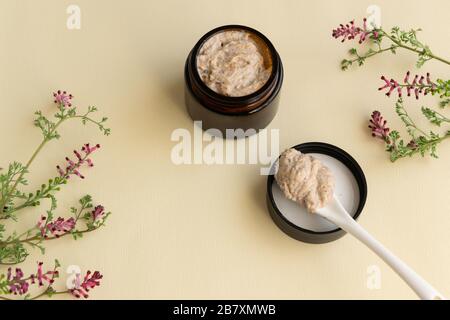 Hygienebademittel. Körper, Gesicht mit wilden Blumen schrubben. Regeneration der Wellness-Therapie Stockfoto