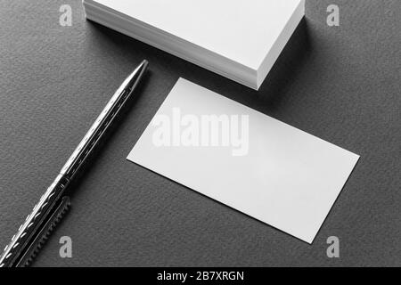 Verspottung von Visitenkartenstapeln in Reihen und Stift auf grauem Hintergrund. Stockfoto