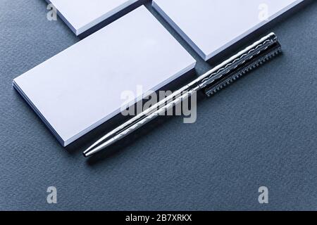 Verspottung von Visitenkartenstapeln in Reihen und Stift auf blauem Hintergrund. Stockfoto