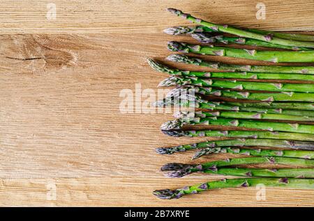 Wilder Spargel auf Holzgrund Stockfoto