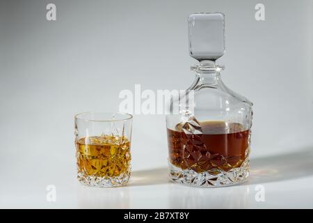 Whisky-Dekanter mit wunderschöner Aussicht und ein Glas Whisky mit Eis auf blauem Hintergrund. Schöne Hintergründe. Alkoholkonzept. Stockfoto