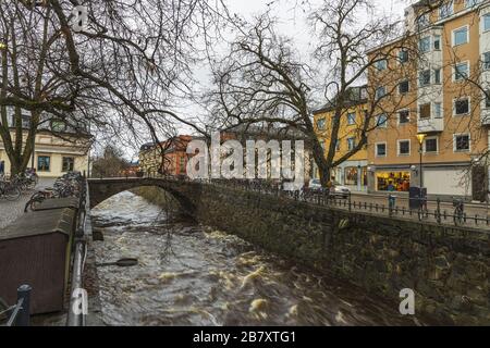 Wunderschöner Blick auf die Straße in der Nähe des Flusses im Hintergrund. Wunderschöner Himmel mit Gewitterwolken an einem Wintertag. Tourismus, Reisekonzept. Europa, Schweden, Uppsala. Stockfoto