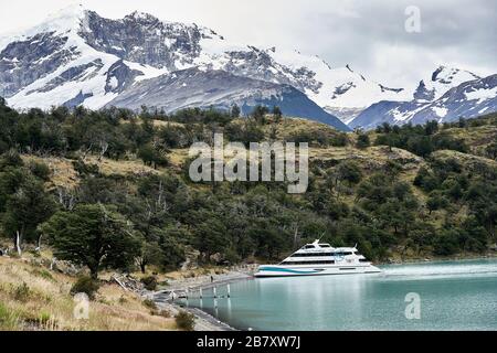 Touristenboot landet in abgelegener Siedlung auf dem See Argentino Stockfoto