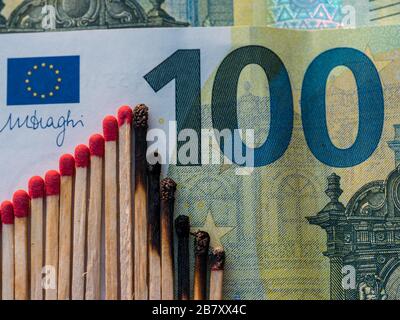 Verbrannte Matchstäbchen: Abstraktes Konzept des Börsencrashs auf 100 Euro Note, flacher Lay Stockfoto