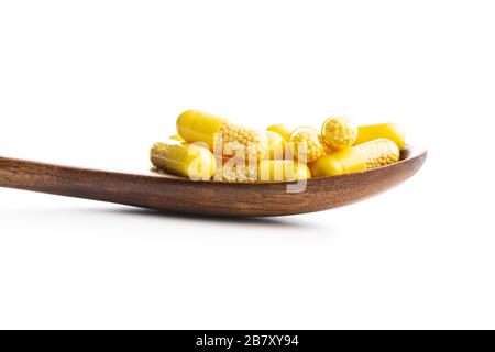 Vitaminkapseln in Holzlöffel. Vitamin-C-Pillen isoliert auf weißem Hintergrund. Stockfoto
