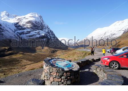 Sonne und Schnee in den schottischen Highlands, sah Glencoe hier in Mitleidenschaft gezogen. Besucher und Parkplatz am Three Sisters Ridge. Schottland. Stockfoto