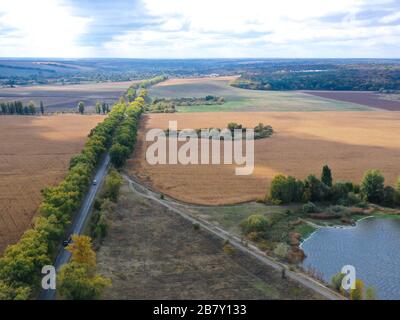 Seen, Wasser, Autmn, die Straße zwischen den Bäumen, Herbstlandschaft im Dorf Stockfoto