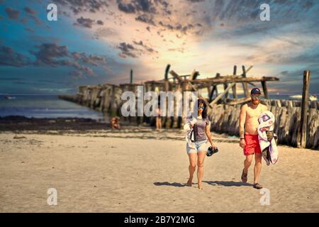 30-09-2019 Riga, Lettland EIN Mann und eine Frau gehen am Strand in der Nähe des Piers entlang Stockfoto