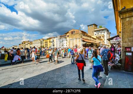 Viele Touristen kaufen und besichtigen die Brücke Ponte Vecchio über den Arno in der Toskana, Florenz, Italien Stockfoto