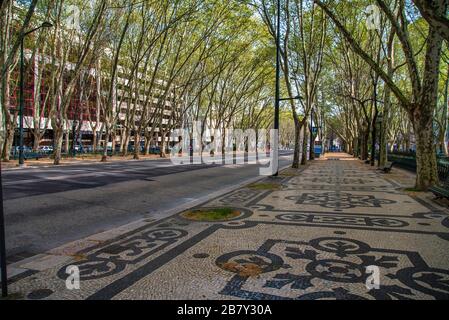 Seltene Aussicht auf die Avenida da Liberdade in Lissabon ohne Verkehr oder Fußgänger, mit dem zentralen Denkmal und dem baumgesäumten Boulevard. Stockfoto