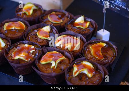 Frisch gebackene britische Cupcakes Muffins mit Karamelläpfeln und braunem Zuckersirup liegen ganz nah Stockfoto