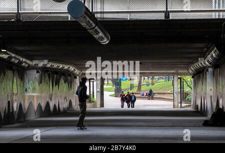 Sacramento, CA, USA. März 2020. Eine Skateboarder-Fahrt führt eine I-5-Unterführung in Richtung Menschen durch, die während des Coronavirus-Ausbruchs am Mittwoch, 18. März 2020 in Sacramento weniger als 6 Fuß voneinander entfernt sind. Kredit: Paul Kitagaki Jr./ZUMA Wire/Alamy Live News Stockfoto