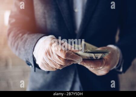 Mann zählt polnische Zloty-Geldscheine in Latex-Schutzhandschuhen. Stockfoto