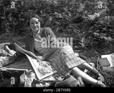 Gut gekleidete, attraktive junge Frau, die eine Kopie der Zeitung "Daily Sketch" nach dem zweiten Weltkrieg im September 1939 liest Stockfoto