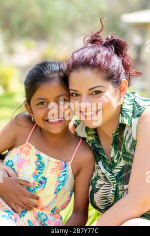 Liebe zwischen einer jungen Mutter und ihrer hübschen Tochter im Freien Stockfoto