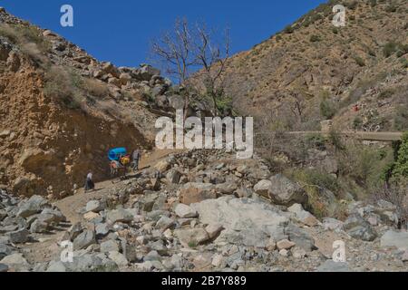 Lokale Menschen, die in den Bergen des hohen Atlas, Marokko, spazieren gehen Stockfoto