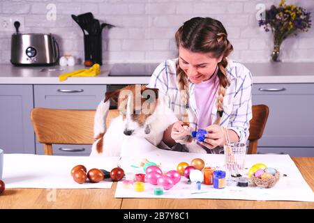 Mädchen und Hund malen ostereier. Osterkonzept Stockfoto