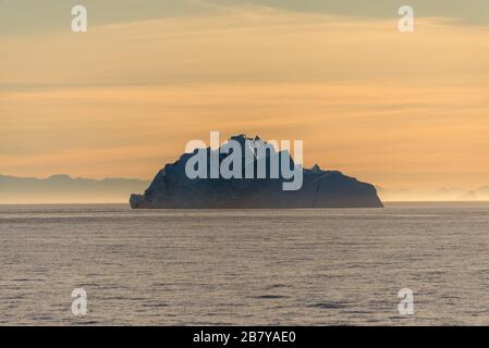 Schöne Sinrise in Grönland. Eisberg auf See. Stockfoto