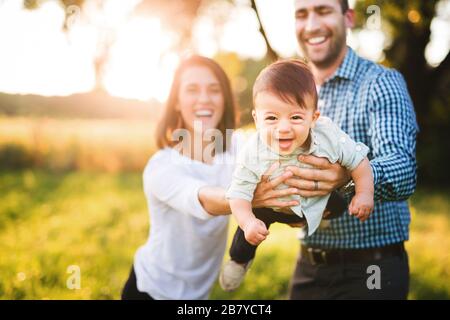 Dreiköpfige Familie mit lachenden kleinen Jungen Stockfoto