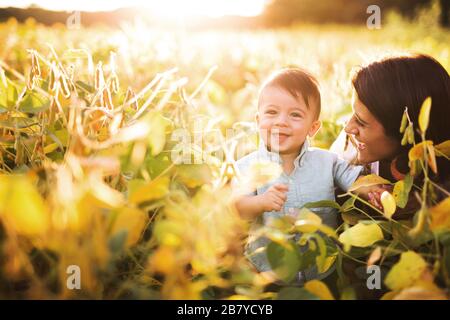 Mutter schaut auf lächelnden kleinen Jungen im Wisconsin Farm Field Stockfoto