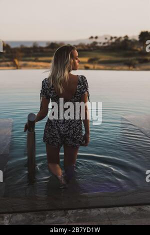 Junge Frau, die sich während des Sonnenuntergangs im mexikanischen Pool entspannen kann Stockfoto