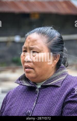 Guilin, China - 10. Mai 2010: Stadtzentrum. Gesichtsaufzug der grassenden Frau mit violettem Hemd. Stockfoto