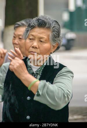 Guilin, China - 11. Mai 2010: Stadtzentrum. Nahaufnahme der vergrauenden Frau, die Tai-Chi-Übungen durchführt. Stockfoto