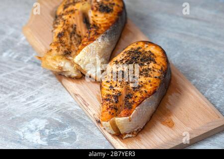 Steaks für Ofenlachs. Zwei rote Scheiben roter Fisch mit Gewürzen. Zu Hause gekochter Fisch zum Abendessen Stockfoto