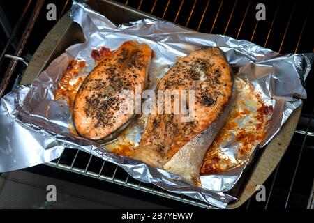 Steaks für Ofenlachs. Zwei rote Scheiben roter Fisch mit Gewürzen. Zu Hause gekochter Fisch zum Abendessen Stockfoto