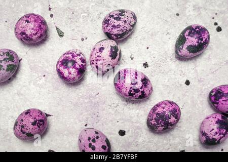 Farbige Wachteleier auf hellem Hintergrund. Draufsicht, Kopierbereich. Konzept der Osterfeiertage. Stockfoto