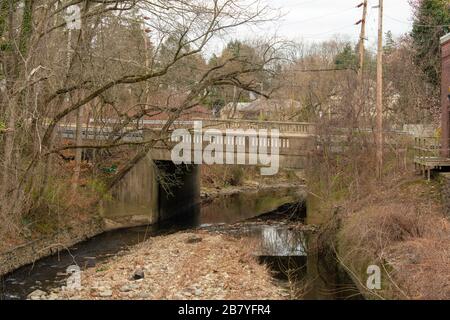 Eine Betonbrücke mit einer Straße und einem darunter verlaufenden Creek Stockfoto