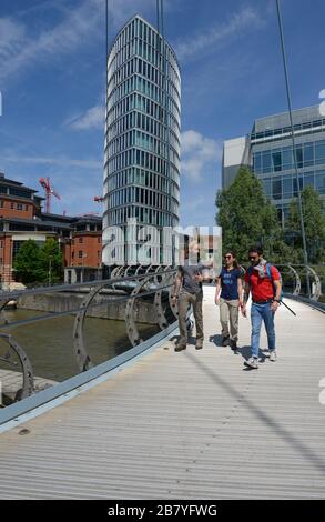 Büroangestellte überqueren die Valentine Pedestrian Bridge über den Fluss Avon in der Nähe der Station Temple Meads in Bristol, Großbritannien Stockfoto