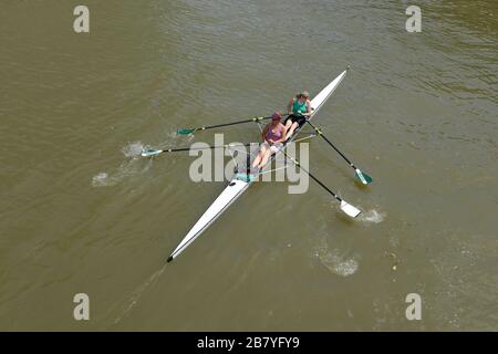 Eine Gruppe von Ruderinnen macht sich auf den Weg entlang des Flusses Avon im schwimmenden Hafen von Bristol, in der Nähe des Bahnhofs Temple Meads, Großbritannien Stockfoto