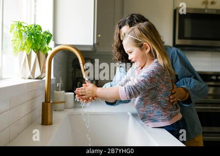 Mutter und Tochter waschen Hände im Spülbecken Stockfoto