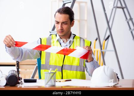 Junger männlicher Architekt, der im Haus an einem Projekt arbeitet Stockfoto