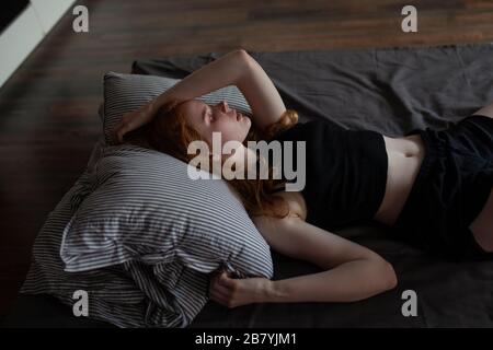 Junge Frau auf Bett liegend Stockfoto