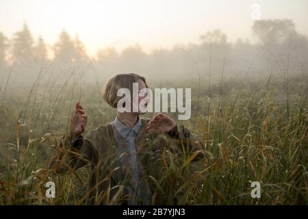 Junge Frau im Feld von langem Gras Stockfoto