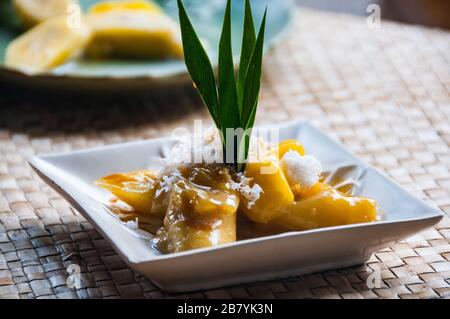 Balinesische Dessert gekochte Banane in Palm Zuckersirup. Es enthält auch Jackfrucht und Kokosnuss Stockfoto