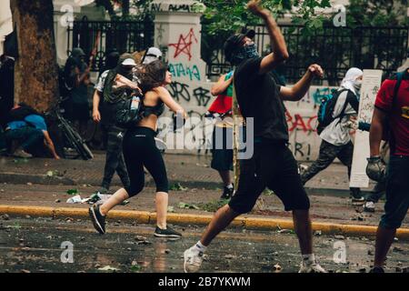 SANTIAGO, CHILE - 8. NOVEMBER 2019 - Demonstranten stehen während der Proteste gegen die Regierung von Pinera wegen der sozialen Krise in den Ländern des Landes vor der Bereitschaftspolizei Stockfoto