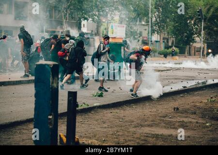 SANTIAGO, CHILE - 8. NOVEMBER 2019 - Demonstranten schützen sich vor Bereitschaftspolizisten mit improvisierten Schilden während der Proteste gegen die Regierung o Stockfoto
