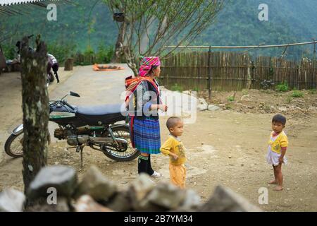 SA pa, Vietnam-22. September 2017. Eine Hmong-Mutter steht am 22. September 2017 in Sa pa, Nordvietnam, zu ihren beiden Kindern in einem Hof vor ihrem Haus Stockfoto