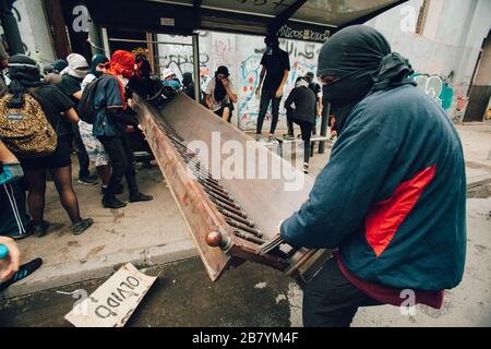 SANTIAGO, CHILE - 8. NOVEMBER 2019 - Demonstranten Beute die Kirche "Parroquia de la Asuncion", um während der Proteste gegen die Regierung Barrikaden zu machen Stockfoto