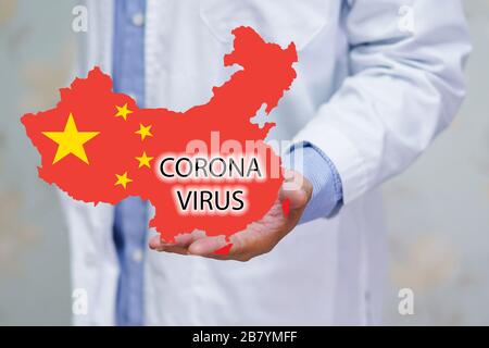 Doktor mit Coronavirus-Alphabet auf china-flagge und Karte verursachen viele Kranke in Wuhan-Stadt in China. Stockfoto